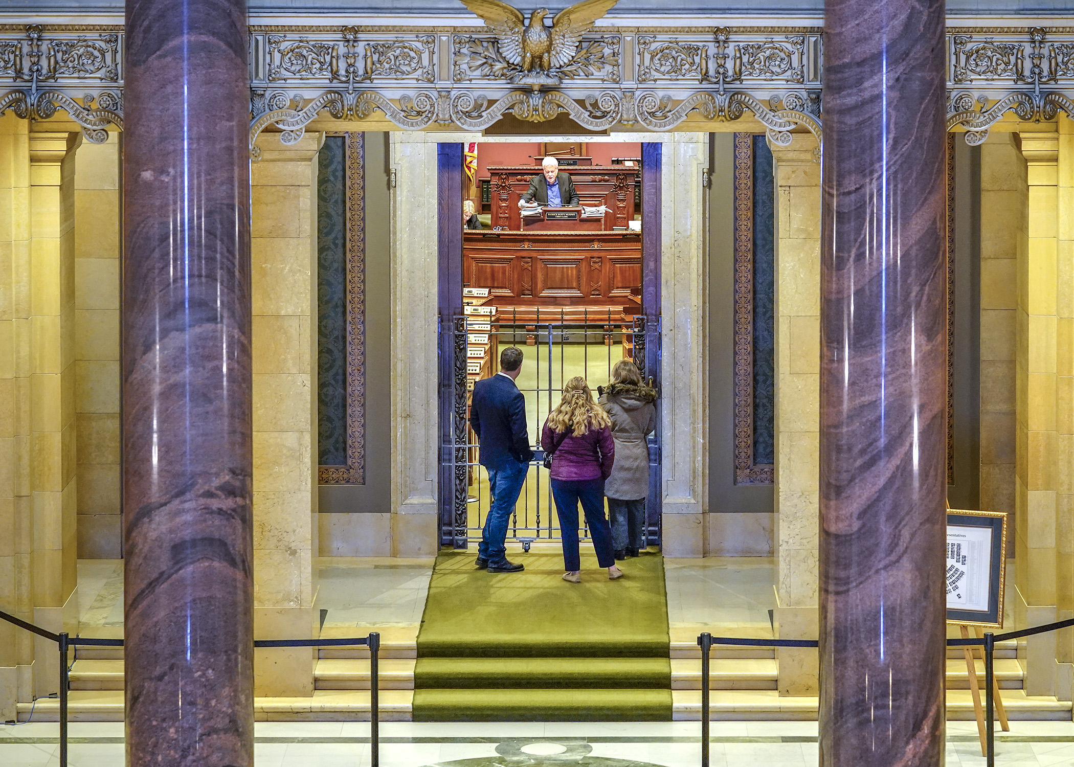 Capitol visitors stop to view the House Chamber and watch Chief Clerk Pat Murphy prepare for the March 18 floor session. (Photo by Andrew VonBank)